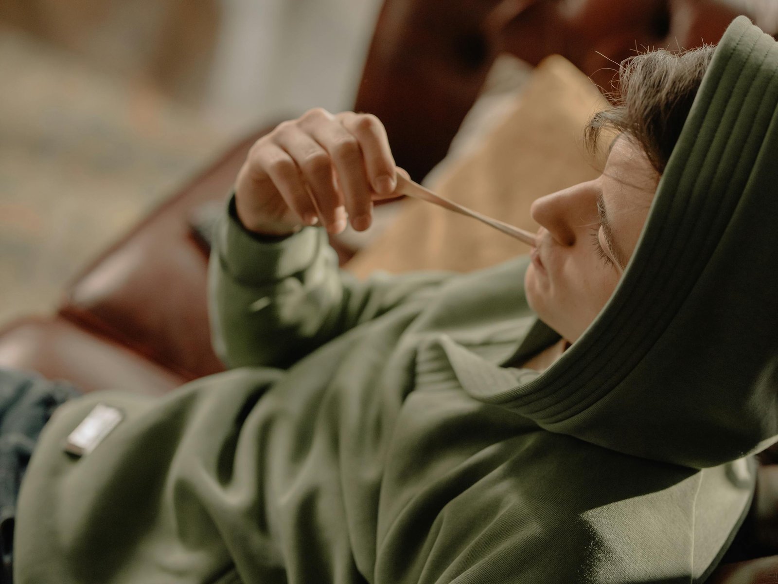 Woman in Green Long Sleeve Shirt Holding Silver Spoon