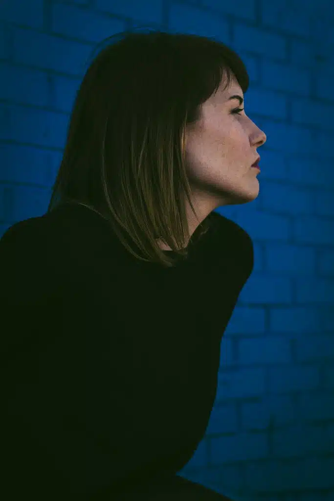 Young Woman in a Black Blouse Sitting and Looking Away