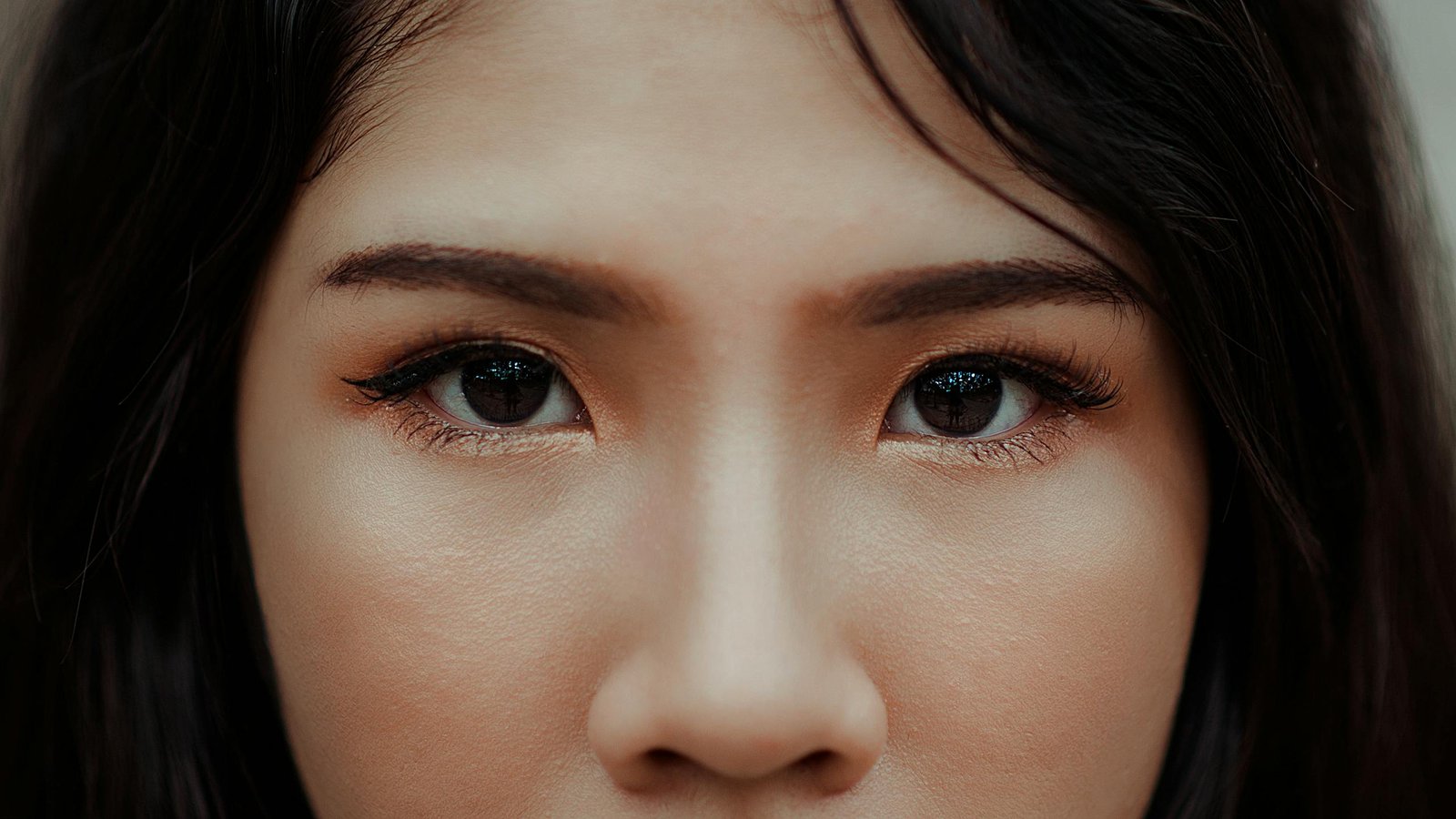 A detailed close-up image showcasing the expressive eyes and natural beauty of a young woman.