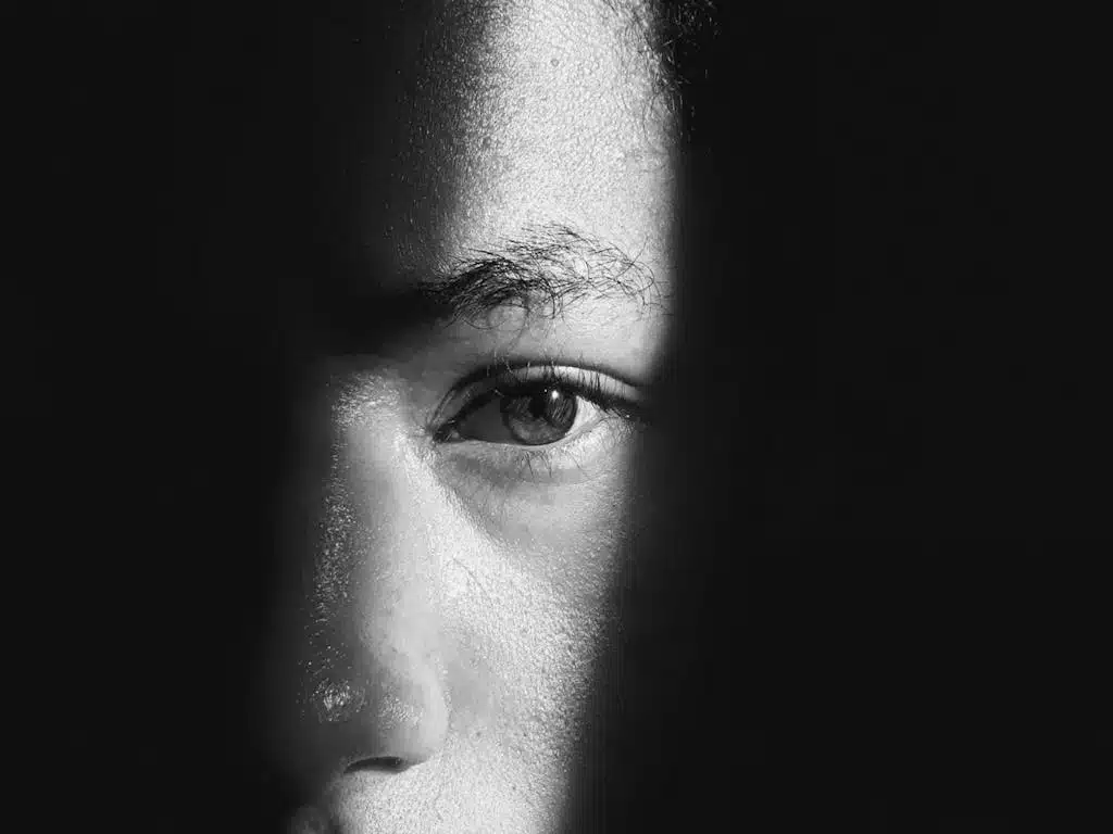 A striking black and white close-up of an eye in dramatic lighting.