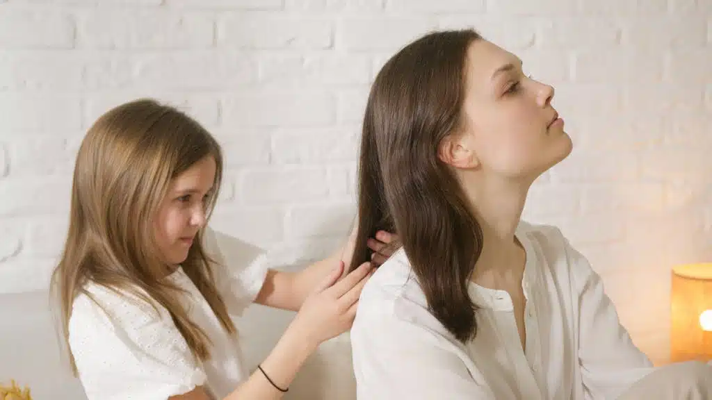A touching scene of a daughter braiding her mother's hair, showcasing family love.