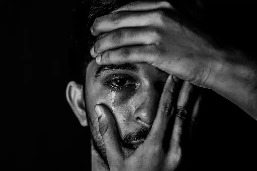 Close-up black and white portrait capturing raw emotion and tears, highlighting the complexity of human feelings.